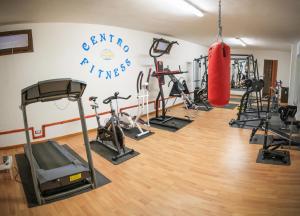 a gym with several tread machines and a punching bag at Abbaidda Hotel in Valledoria