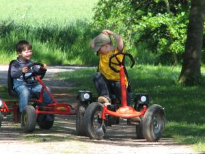 two young boys riding on toy cars at Ferienhof Utech in Wenkendorf