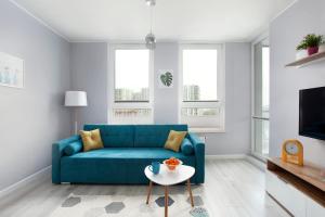 un soggiorno con divano blu e tavolo di Luxury Apartment Solvo a Danzica