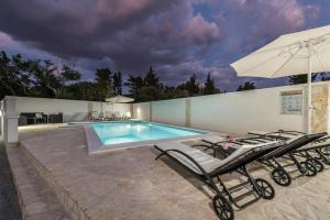 basen z 2 leżakami i parasolem w obiekcie Andy 2 modern & centrally ap with a pool w Novalji +37 zdjęć
