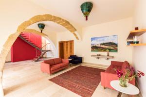 a living room with an archway and red chairs at Casa de Atalaia in Palmela