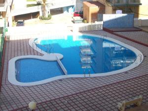 a large swimming pool with a slide in a building at Infante - Primera Línea de Playa in Playa de Gandia +30 photos