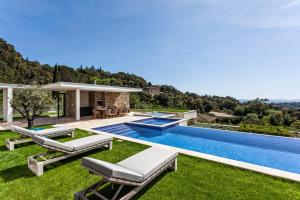 un cortile con piscina e una casa di Villa Colibri a La Croix-Valmer