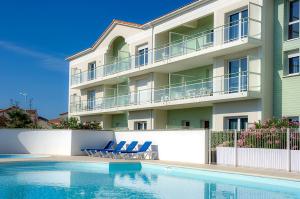 un hotel con piscina frente a un edificio en Résidence Goélia La Grande Plage, en Saint Gilles Croix de vie