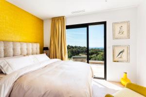 una camera con un letto bianco e una parete gialla di Villa Colibri a La Croix-Valmer Altre 51 foto