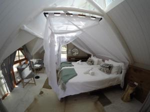 a bedroom with a white bed in an attic at Kalahari Game Lodge in Koës