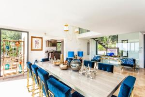 una sala da pranzo con un lungo tavolo e sedie blu di Villa Colibri a La Croix-Valmer