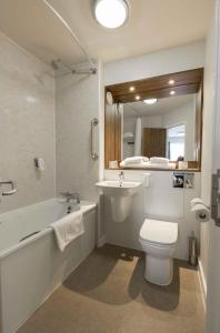 a bathroom with a sink and a toilet and a bath tub at Starling Cloud in Aberystwyth