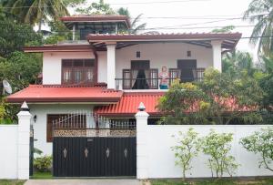 a woman standing on the balcony of a house at Movi Holiday Apartment in Bentota