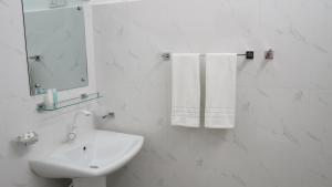 La salle de bains est pourvue d'un lavabo, d'un miroir et de serviettes. dans l'établissement Senomaal Sigiri Resort, à Dambulla