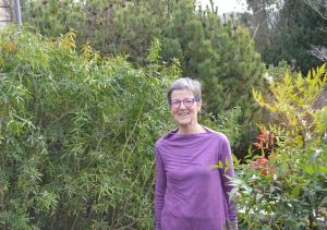 a woman wearing glasses standing in a garden at Jardin de Belle Vue in Quimperlé