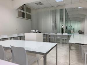 uma sala de jantar com mesas brancas e cadeiras brancas em Morin 10 Rome Exclusive Suites em Roma