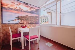 a dining room with a table and chairs and a window at Funchal City Apartments in Funchal