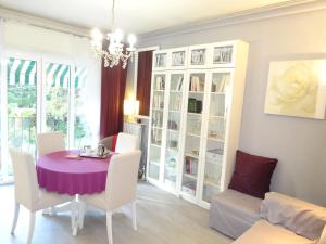 a dining room with a purple table and white chairs at LES GRANDS CEDRES C1 7 Avenue de Fabron in Nice