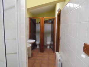 a hallway of a bathroom with two toilets and a sink at Albergue Areitz Soroa in Arce