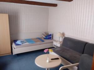 Kloster GrÃ¶ningenにあるGasthof Jacobshöheのベッド、ソファ、テーブルが備わる小さな客室です。