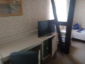 a room with a desk with a television and a bed at Gasthof Jacobshöhe in Kloster GrÃ¶ningen