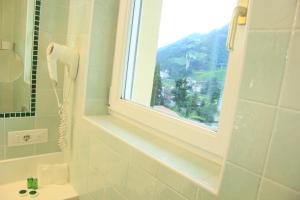 a bathroom with a phone on the wall and a window at Hotel Hanny in Bolzano