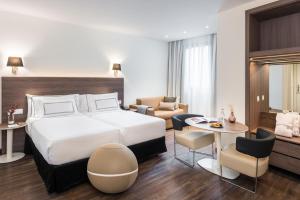 una camera d'albergo con letto e soggiorno di Melia Madrid Serrano a Madrid