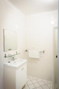 Baño blanco con lavabo y espejo en The Anglers Inn en Wallaroo