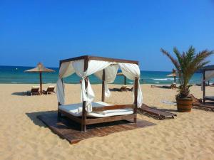 a bed on a beach with umbrellas and the ocean at Menada Apartments in Sunny Beach in Sunny Beach +28 photos