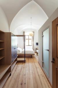 een slaapkamer met een bed en een slaapkamer met houten vloeren bij das asam in Aldersbach