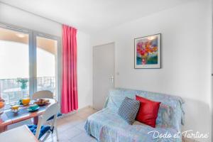 uma sala de estar com um sofá e uma mesa em Quiet cute 1 bedroom with terrace - Dodo et Tartine em La Londe-les-Maures