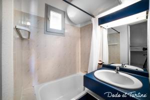 uma casa de banho com um lavatório, uma banheira e uma janela em Quiet cute 1 bedroom with terrace - Dodo et Tartine em La Londe-les-Maures