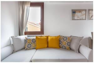 a white couch with yellow pillows on it in a room at Biennale Family Apartment in Venice in Venice