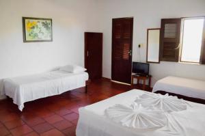 a hotel room with two beds and a television at Pousada Morada do Sol in Canoa Quebrada +76 photos