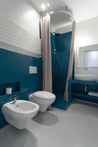 a blue bathroom with a toilet and a sink at Casa ALBERTINI in Como