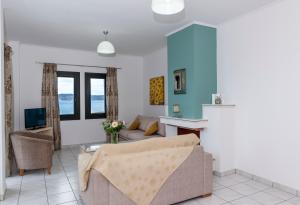een woonkamer met een bank en een tafel bij Sunrise Beachfront Apartment in Sitia