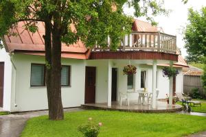 a house with a balcony and a table and chairs at Männi Guesthouse in Haapsalu