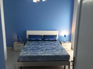 a blue bedroom with a bed with a blue wall at Apartment Xenia in Mongiove