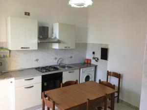 cocina con mesa y fogones horno superior en Apartment Xenia, en Mongiove