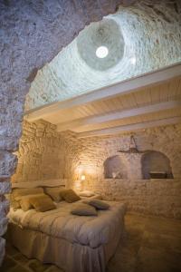 una camera da letto con un letto e una parete in pietra di IL TRULLO DELLA MASSAIA ad Alberobello
