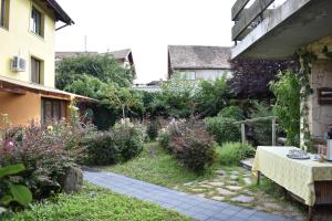 a garden with a table and some bushes and a building at Pension Maria in Sibiu