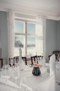 a white table with wine glasses and a window at Kongsvinger Castle Hotel & Resort in Kongsvinger