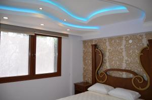 une chambre avec un lit et un plafond bleu dans l'établissement george's boutique hotel, à Fethiye