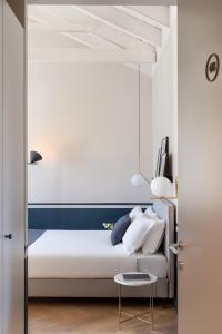 una camera con un letto bianco e un tavolo di Velvet Grey Boutique Hotel a Milano