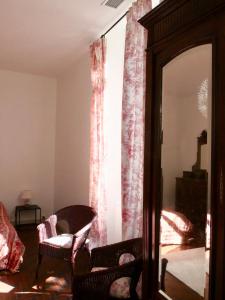 - un salon avec un miroir et une chaise dans l'établissement Douceur Girondine, à Saint-Selve
