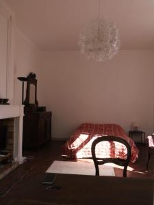 a bedroom with a bed and a chandelier at Douceur Girondine in Saint-Selve