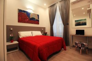 a bedroom with a red bed and a painting on the wall at La Casa di Geppa in Naples