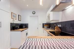 eine Küche mit weißen Schränken und einer Arbeitsplatte in der Unterkunft Stylish Town Centre Apartment Close to Beach and Shops in Bournemouth
