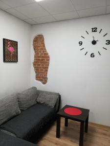 a living room with a couch and a clock on the wall at Ubytovanie Queen in Nováky