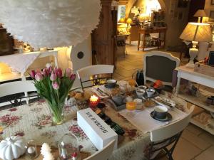 una mesa con comida y flores. en La Felixinette, en Lalbenque