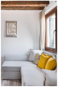 a white couch with yellow pillows in a room at Biennale Family Apartment in Venice in Venice