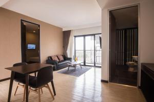a living room with a table and a couch at Amanta Hotel Nongkhai in Nong Khai