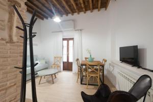 a living room with a table and a tv at Casas del Albaicín in Granada