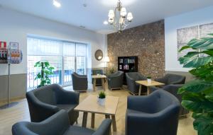 - une salle d'attente avec des tables et des chaises bleues dans l'établissement Hotel Sur Málaga, à Malaga